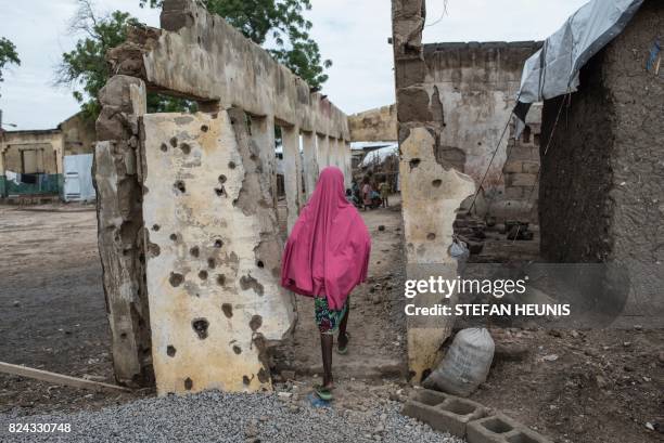 Girl walks through the site where the Nigerian Air Force mistakenly bombed the Rann Internally-Displaced Peoples' camp in northeastern Nigeria near...