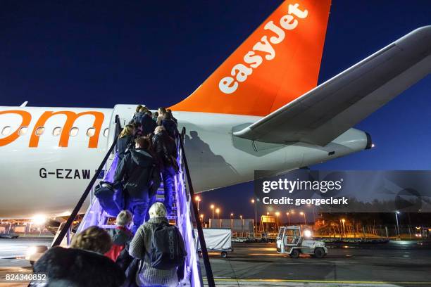 passengers boarding an easyjet flight at dusk - easyjet stock pictures, royalty-free photos & images