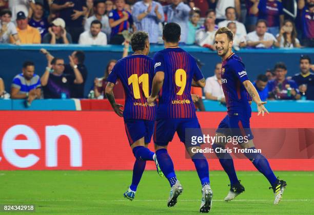 Ivan Rakitic of Barcelona celebrates his goal with teammates Neymar and Luis Suarez in the first half against the Real Madrid during their...