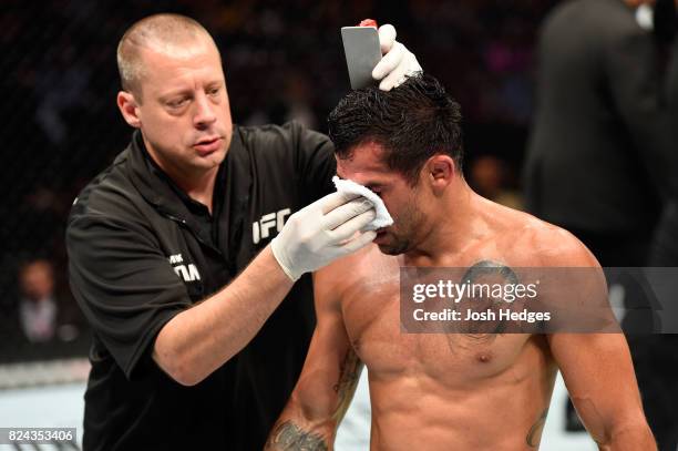 Renan Barao of Brazil is attended to in between rounds of his 140-pound catchweight bout against Aljamain Sterling during the UFC 214 event at Honda...