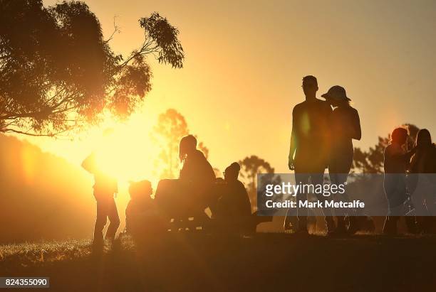 Festival goers watch the sunset during Splendour in the Grass 2017 on July 21, 2017 in Byron Bay, Australia.