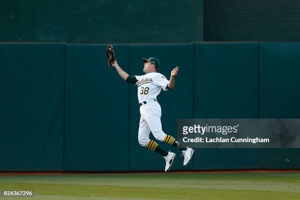 Jaycob Brugman of the Oakland Athletics catches a fly ball hit by Robbie Grossman of the Minnesota Twins in the fifth inning at Oakland Alameda...