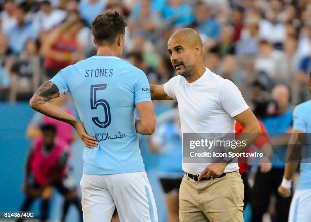 Manchester City defender John Stones talks with head coach Pep Guardiola during the second half of a International Champions Cup match between...