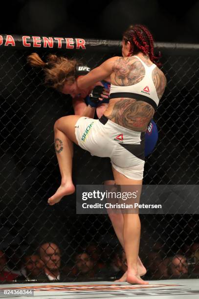Cris Cyborg of Brazil knees Tonya Evinger in their UFC women's featherweight championship bout during the UFC 214 event at Honda Center on July 29,...