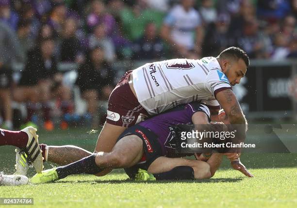 Cooper Cronk of the Storm is challenged by Addin Fonua-Blake of the Sea Eagles during the round 21 NRL match between the Melbourne Storm and the...