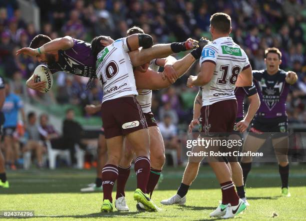 Jesse Bromwich of the Storm is lifted by Martin Taupau of the Sea Eagles during the round 21 NRL match between the Melbourne Storm and the Manly Sea...