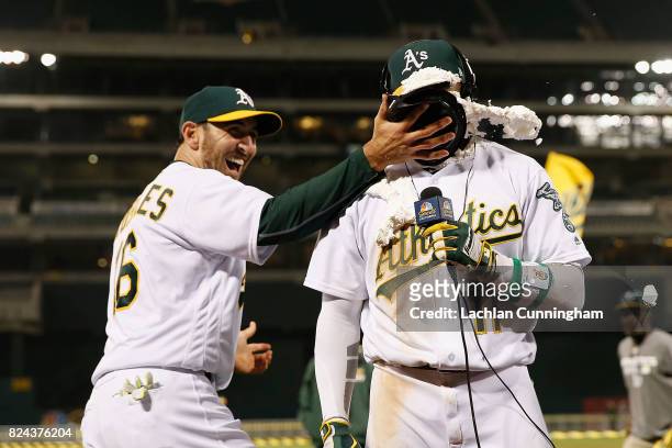 Rajai Davis of the Oakland Athletics is hit with a pie by teammate Adam Rosales of the Oakland Athletics after Davis hit a two-run walk-off home run...