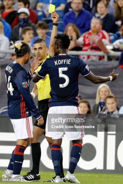 Referee Nima Saghafi issues a yellow card to New England Revolution midfielder Gershon Koffie during an MLS match between the New England Revolution...