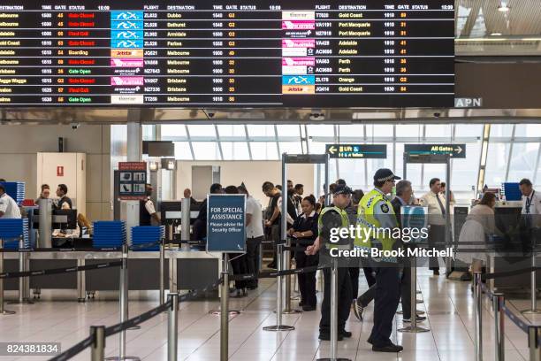 Police guard the passenger security check area at Sydney Airport on July 30, 2017 in Sydney, Australia. Counter terrorism police raided four houses...