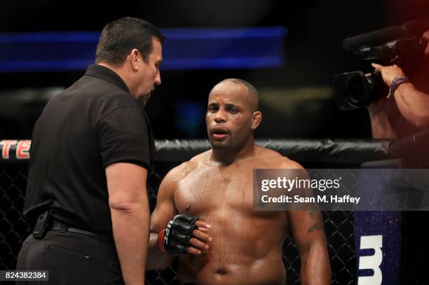 Daniel Cormier is checked by referee John McCarthy after receiving an accidental headbutt from opponent Jon Jones during the UFC 214 event at Honda...
