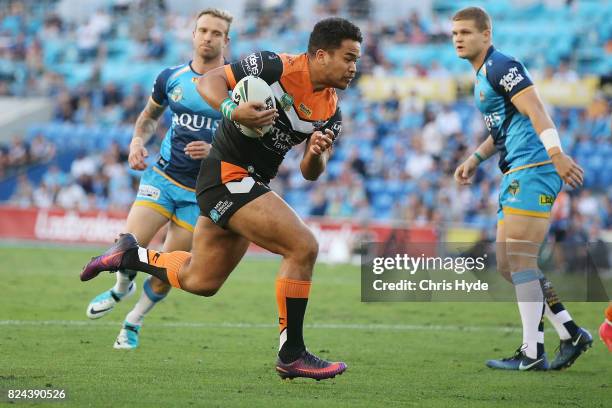 Esan Marsters of the Tigers makes a break to score a try during the round 21 NRL match between the Gold Coast Titans and the Wests Tigers at Cbus...