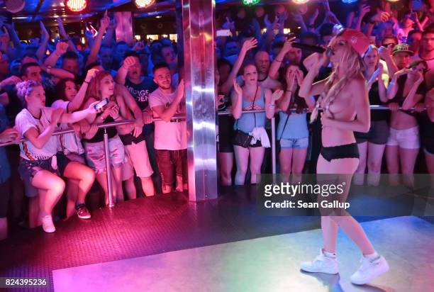 Mostly German-speaking visitors cheer as German singer Mia Julia, a former porn actress, performs topless at the Oberbayern disco on the Ballermann...