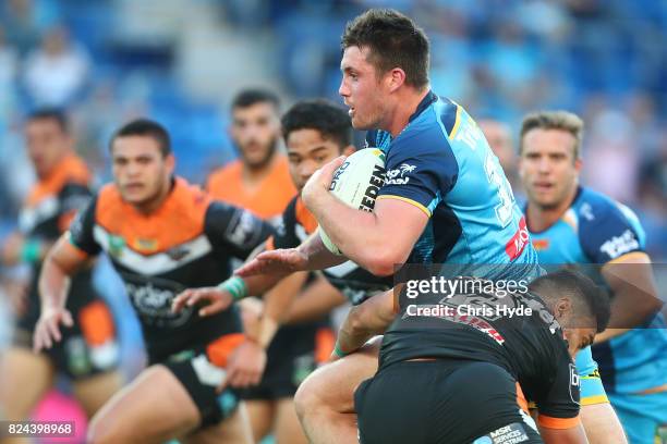 Joe Greenwood of the Titans runs the ball during the round 21 NRL match between the Gold Coast Titans and the Wests Tigers at Cbus Super Stadium on...