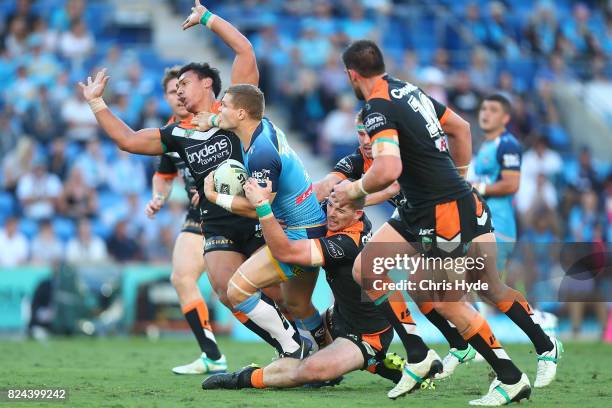 Dale Copley of the Titans is tackled during the round 21 NRL match between the Gold Coast Titans and the Wests Tigers at Cbus Super Stadium on July...