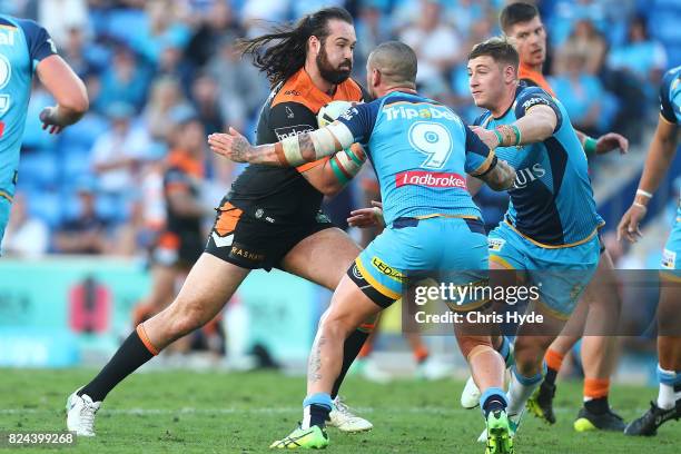Aaron Woods of the Tigers runs the ball during the round 21 NRL match between the Gold Coast Titans and the Wests Tigers at Cbus Super Stadium on...