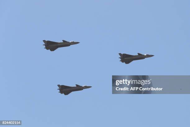 Chinese J-20 stealth fighter jets fly past during a military parade at the Zhurihe training base in China's northern Inner Mongolia region on July...