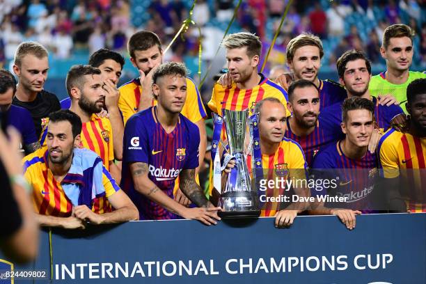 Andres Iniesta and Neymar Jr of Barcelona lift the tournament winner's trophy after the International Champions Cup match between Barcelona and Real...
