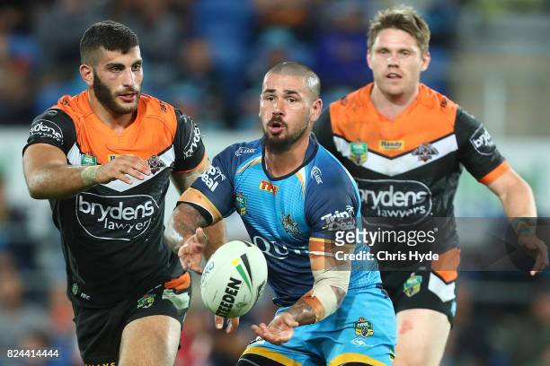 Nathan Peats of the Titans passes during the round 21 NRL match between the Gold Coast Titans and the Wests Tigers at Cbus Super Stadium on July 30,...