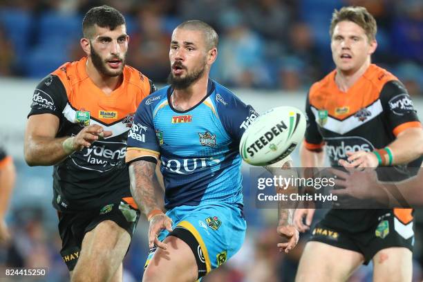 Nathan Peats of the Titans passes during the round 21 NRL match between the Gold Coast Titans and the Wests Tigers at Cbus Super Stadium on July 30,...