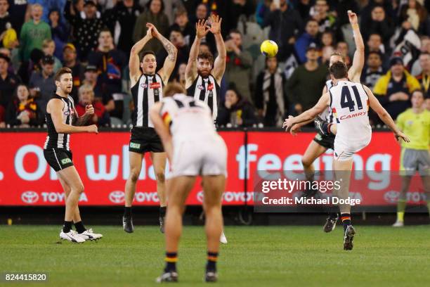 Mitchell McGovern of the Crows kicks the ball for a goal over Tyson Goldsack of the Magpies to seal a draw during the round 19 AFL match between the...