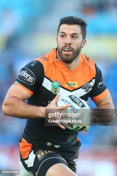 James Tedesco of the Tigers runs the ball during the round 21 NRL match between the Gold Coast Titans and the Wests Tigers at Cbus Super Stadium on...
