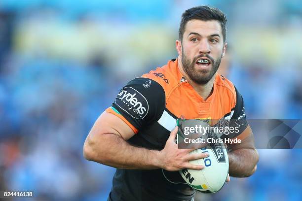 James Tedesco of the Tigers runs the ball during the round 21 NRL match between the Gold Coast Titans and the Wests Tigers at Cbus Super Stadium on...