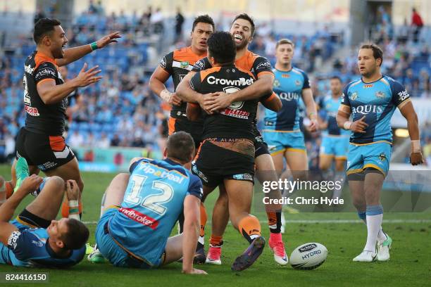 Esan Marsters of the Tigers celebrates a try with James Tedesco during the round 21 NRL match between the Gold Coast Titans and the Wests Tigers at...