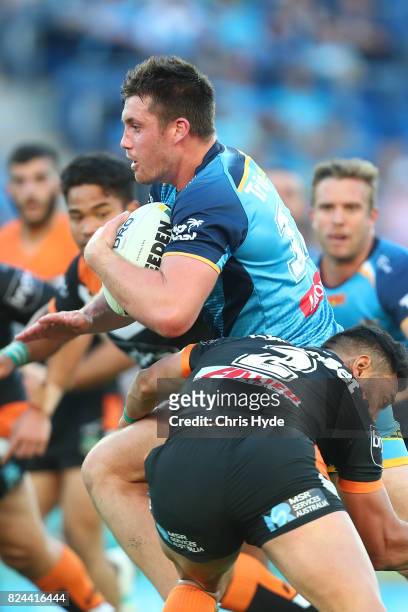 Joe Greenwood of the Titans runs the ball during the round 21 NRL match between the Gold Coast Titans and the Wests Tigers at Cbus Super Stadium on...
