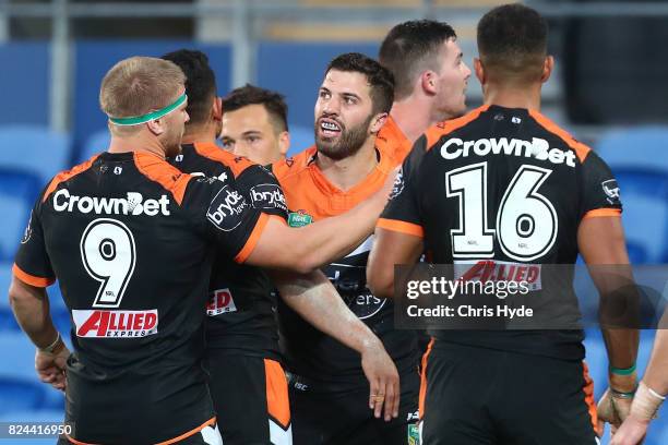 James Tedesco of the Tigers celebrates a try with team mates during the round 21 NRL match between the Gold Coast Titans and the Wests Tigers at Cbus...