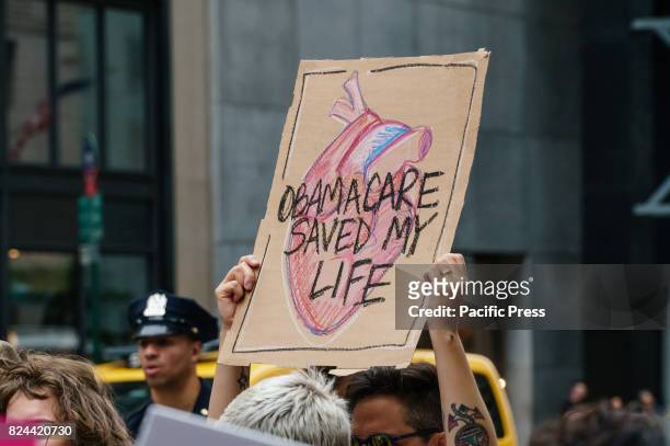 Participants hold signs while protesting the repeal and replacement of the Affordable Care Act. At back-to-back rallies in midtown Manhattan, liberal...