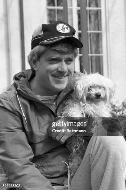 Before departing for Chicago, talk-show host Phil Donahue stops to relax and pose with his Maltese dog, Teeda. Winning a national daytime Emmy award...