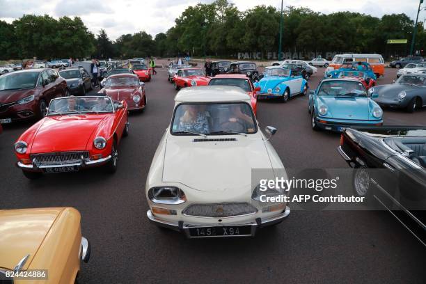 Enthusiasts travel in a Ami 6 Citroën while taking part in the "10th Vincennes en Anciennes" vintage vehicle parade at Chateau de Vincennes in Paris...