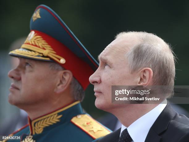 Russian President Vladimir Putin and Defence Minister Sergei Shoigu watch the military parade on Neva river during the Navy Day celebration on July...