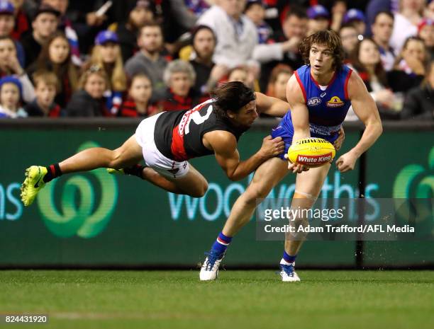 IMELBOURNE, AUSTRALIA Liam Picken of the Bulldogs is tackled by Mark Baguley of the Bombers during the 2017 AFL round 19 match between the Western...