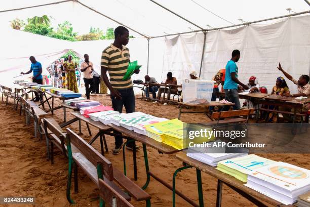 Man picks ballot papers prior to casting his vote in Senegal's legislative election, on July 30, 2017 in Dakar. Senegalese voters cast ballots on...