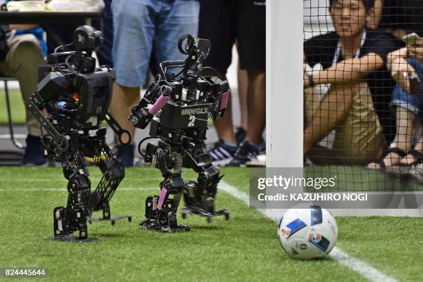 Humanoid from France's Bordeaux University moves toward the ball beside a humanoid from a Chinese team during their kid-size android football...