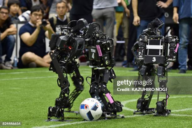 Humanoids from France's Bordeaux University fight for the ball with a member of the Chinese team during their kid-size android football tournament...