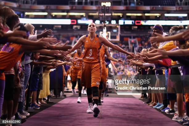 Diana Taurasi of the Phoenix Mercury high fives fans as she walks off the court following the first half of the WNBA game against the San Antonio...