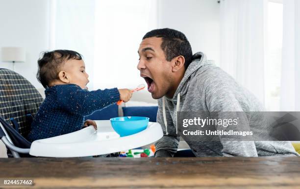 baby voeding vader van de jongen - asian spoon feeding stockfoto's en -beelden
