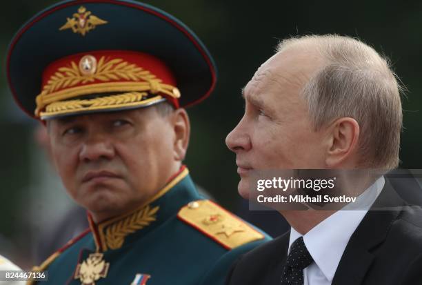 Russian President Vladimir Putin and Defence Minister Sergei Shoigu watch the military parade on Neva river during the Navy Day celebration on July...