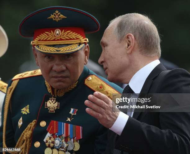 Russian President Vladimir Putin and Defence Minister Sergei Shoigu watch the military parade on Neva river during the Navy Day celebration on July...