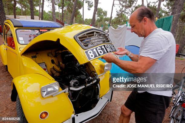 Participant closes the hood of his Citroen classic car 2CV before the parade at Ericeira village during the World 2017 2CV Meeting July 30, 2017. -...