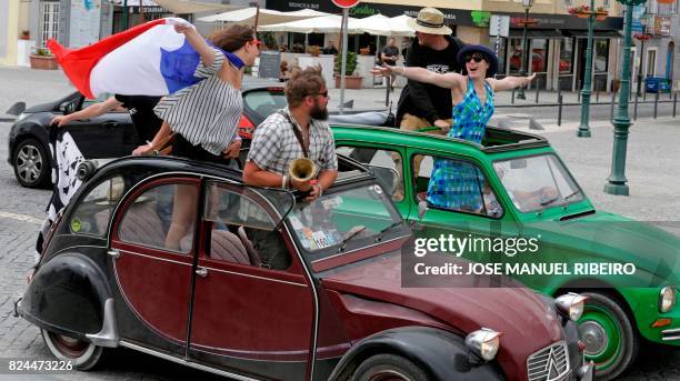 Participants stand in their vehicles during the parade of Citroen classic cars 2CV in Mafra during the World 2017 2CV Meeting July 30, 2017. - The...