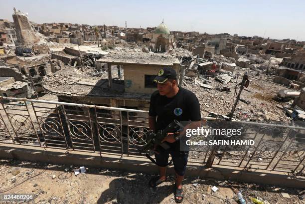 Member of the Iraqi Counter-Terrorism Service stands on the balcony of a damaged building in the old city of western Mosul on July 30, 2017.