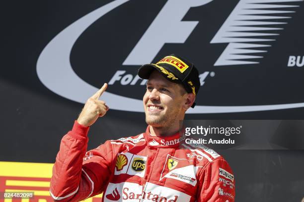 Race winner Sebastian Vettel of Germany and Ferrari celebrates on the podium during the Formula One Grand Prix of Hungary at Hungaroring on July 30,...