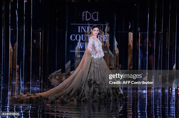 Indian bollywood actress Alia Bhat presents a creation by Indian fashion designer Manish Malhotra during the FDCI India Couture week 2017 in New...