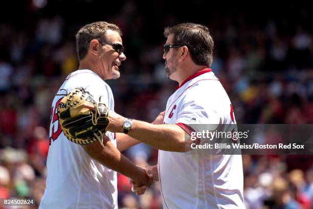 Former Boston Red Sox player Mike Lowell shakes hands with Jason Varitek after throwing out the ceremonial first pitch during a 2007 World Series...