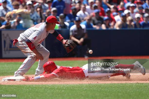 Russell Martin of the Toronto Blue Jays slides safely into third base as he advances on a single by Justin Smoak in the third inning during MLB game...