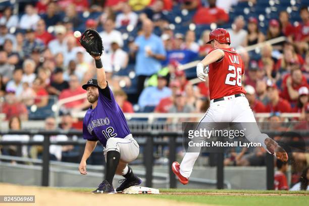 Mark Reynolds of the Colorado Rockies makes the catch to get Adam Lind of the Washington Nationals at first base in the third inning during game two...