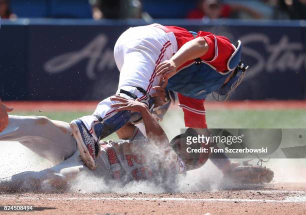 Ben Revere of the Los Angeles Angels of Anaheim slides safely into home plate to score on a sacrifice fly in the fifth inning during MLB game action...